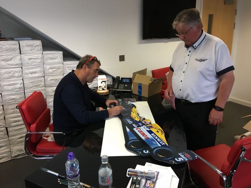 Nigel Mansell signing items for Rob in his Jersey office 
